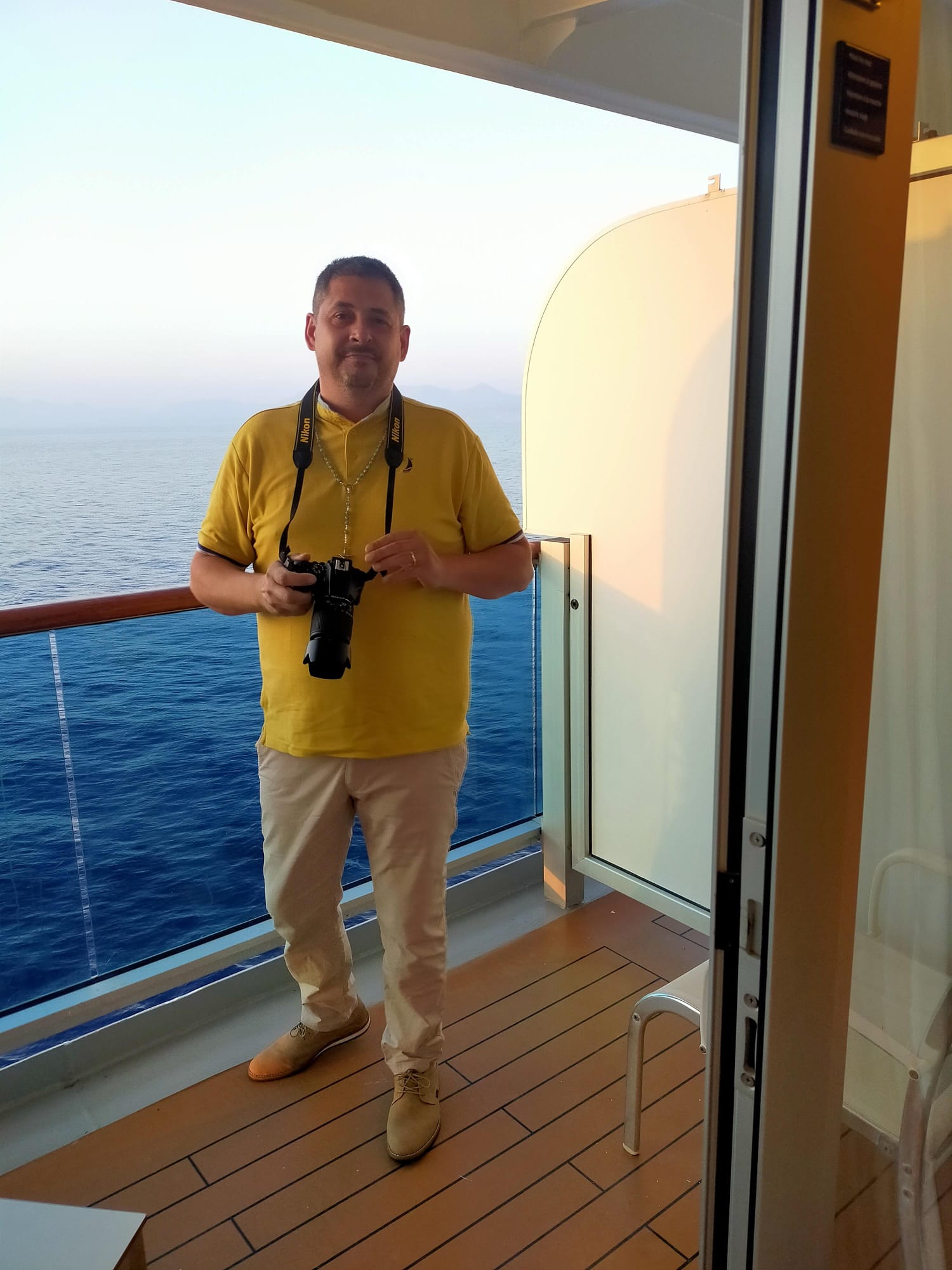 Luis Chamorro en el balcón con su cámara Nikon, durante un crucero